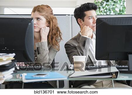 Stock Image - Business people bored at desks. Fotosearch