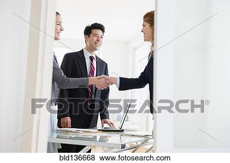 Business people shaking hands in office View Large Photo Image Stock Photo - Business people shaking hands in office. Fotosearch