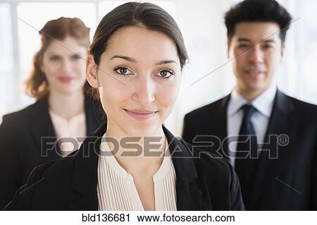 Stock Image - Business people smiling in office. Fotosearch