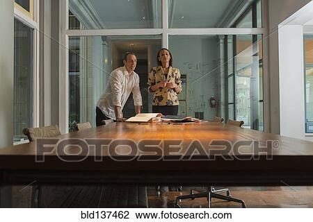 Stock Image - Business people standing in conference room. Fotosearch