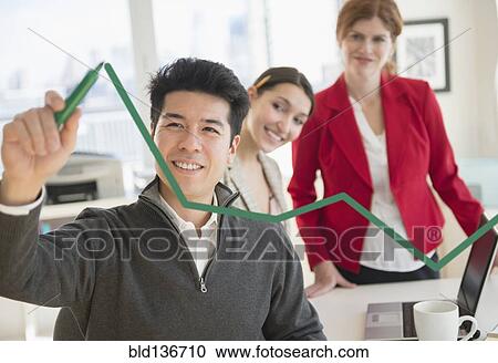 Stock Image - Businessman drawing graph on window in office. Fotosearch