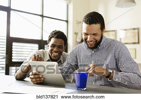 Stock Image - Businessmen working together in office. Fotosearch