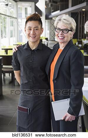 Stock Image - Businesswoman and water smiling in restaurant. Fotosearch