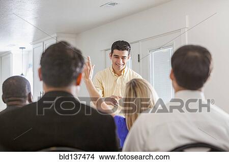 Picture - Businesswoman raising her hand in presentation. Fotosearch