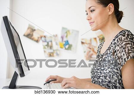 Stock Image - Businesswoman working at computer in office. Fotosearch