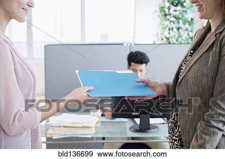 Stock Photo - Businesswomen working together in office. Fotosearch