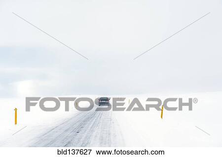 Stock Photo - Car driving on rural road in snowy landscape. Fotosearch