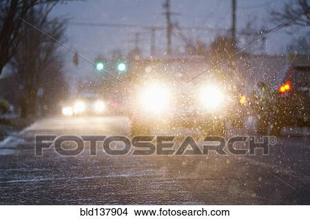 Car driving on snowy urban street at night View Large Photo Image Picture - Car driving on snowy urban street at night. Fotosearch