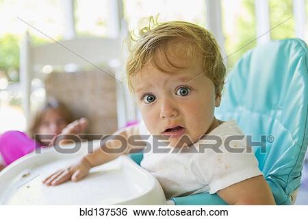 Stock Photograph - Caucasian boy sitting in high chair. Fotosearch
