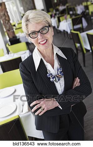 Stock Image - Caucasian businesswoman smiling in restaurant. Fotosearch
