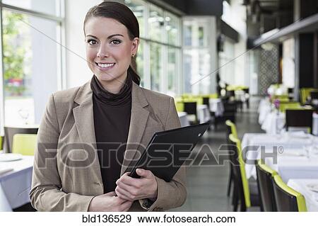 Stock Photo - Caucasian businesswoman standing in restaurant. Fotosearch