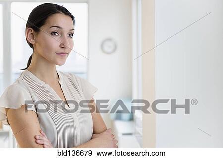 Stock Photo - Caucasian businesswoman standing in office. Fotosearch