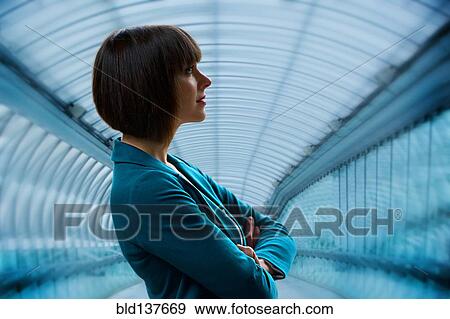 Stock Photo - Caucasian businesswoman standing in tunnel. Fotosearch