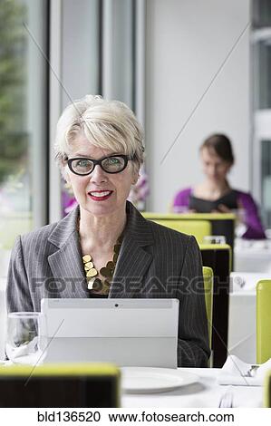 Caucasian businesswoman using tablet computer in restaurant View Large Photo Image Stock Image - Caucasian businesswoman using tablet computer in restaurant. Fotosearch