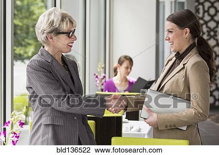 Caucasian businesswomen shaking hands in restaurant View Large Photo Image Stock Image - Caucasian businesswomen shaking hands in restaurant. Fotosearch