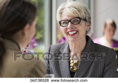 Caucasian businesswomen talking in restaurant View Large Photo Image Stock Photo - Caucasian businesswomen talking in restaurant. Fotosearch