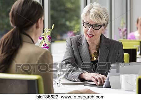 Stock Photo - Caucasian businesswomen working in restaurant. Fotosearch