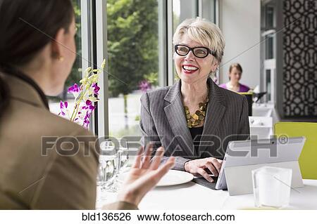 Stock Photograph - Caucasian businesswomen working in restaurant. Fotosearch