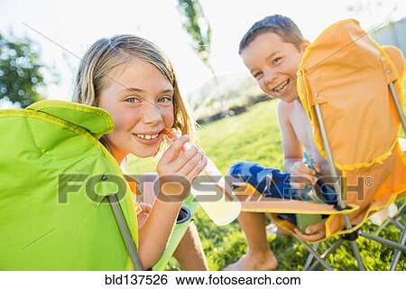 Stock Photograph - Caucasian children drinking soda in backyard. Fotosearch