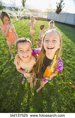 Stock Photography - Caucasian children drinking soda in backyard. Fotosearch