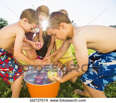 Caucasian children playing with water balloons in backyard View Large Photo Image Picture - Caucasian children playing with water balloons in backyard. Fotosearch