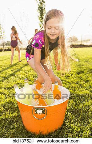 Stock Image - Caucasian girl drinking soda in backyard. Fotosearch