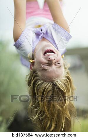 Caucasian girl hanging upside down outdoors View Large Photo Image Picture - Caucasian girl hanging upside down outdoors. Fotosearch