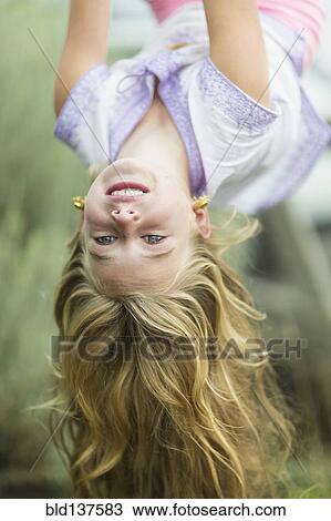 Caucasian girl hanging upside down outdoors View Large Photo Image Stock Image - Caucasian girl hanging upside down outdoors. Fotosearch