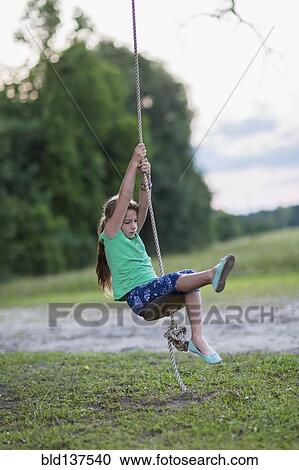 Caucasian girl playing on rope swing View Large Photo Image Stock Image - Caucasian girl playing on rope swing. Fotosearch