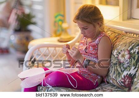Caucasian girl sewing fairy wings on sofa View Large Photo Image Stock Photo - Caucasian girl sewing fairy wings on sofa. Fotosearch