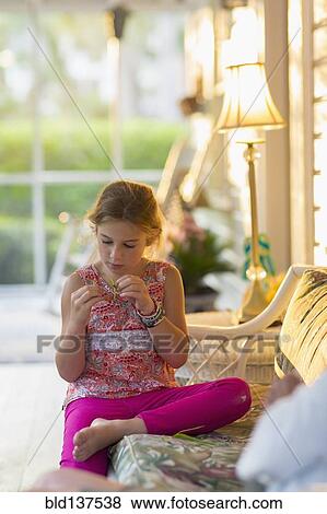 Stock Photo - Caucasian girl sitting on patio. Fotosearch