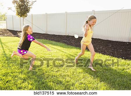 Caucasian girl throwing water balloons in backyard View Large Photo Image Stock Photography - Caucasian girl throwing water balloons in backyard. Fotosearch