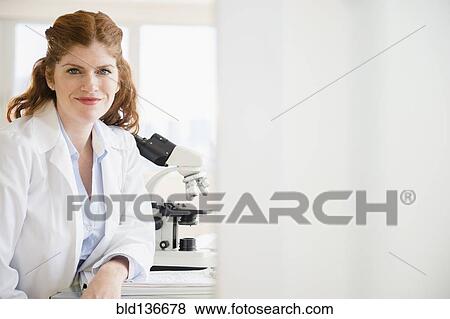Caucasian scientist smiling in lab View Large Photo Image Stock Photo - Caucasian scientist smiling in lab. Fotosearch
