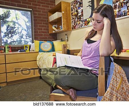 Stock Photo - Caucasian student reading in dorm room. Fotosearch