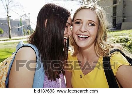 Stock Image - Caucasian students laughing on campus. Fotosearch