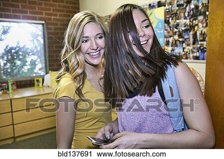 Stock Image - Caucasian students talking in dorm room. Fotosearch