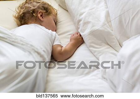 Stock Photography - Caucasian toddler asleep in bed. Fotosearch