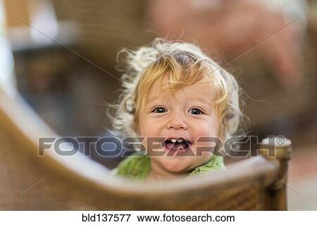 Stock Photo - Caucasian toddler standing on chair. Fotosearch