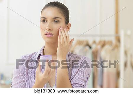 Caucasian woman applying moisturizer to face View Large Photo Image Stock Image - Caucasian woman applying moisturizer to face. Fotosearch