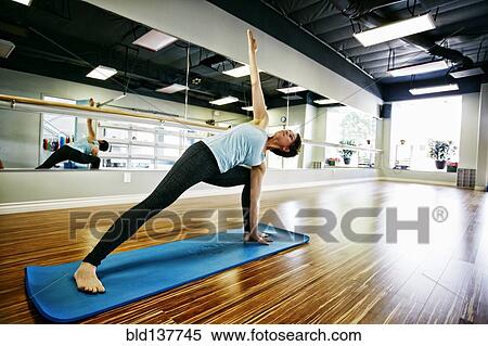 Caucasian woman practicing yoga in studio View Large Photo Image Stock Photography - Caucasian woman practicing yoga in studio. Fotosearch