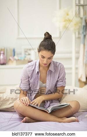 Caucasian woman reading magazine on bed View Large Photo Image Stock Photo - Caucasian woman reading magazine on bed. Fotosearch