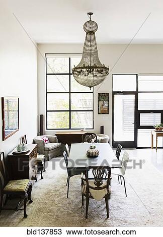 Chandelier over dining table and chairs in dining room View Large Photo Image Stock Image - Chandelier over dining table and chairs in dining room. Fotosearch
