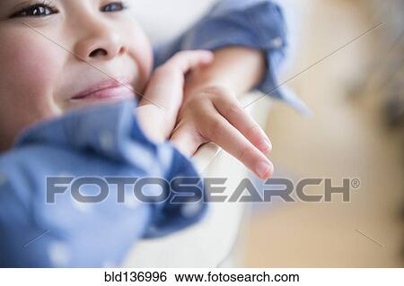 Stock Photograph - Close up of Filipino girl resting chin in hands. Fotosearch
