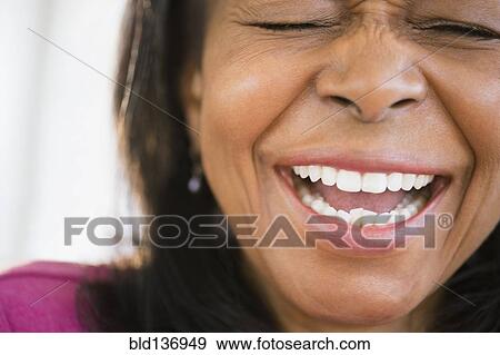 Stock Photo - Close up of mixed race woman laughing. Fotosearch