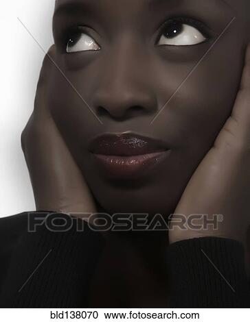 Stock Image - Close up of woman holding her face. Fotosearch