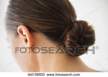 Stock Image - Close up of woman wearing bun in hair. Fotosearch