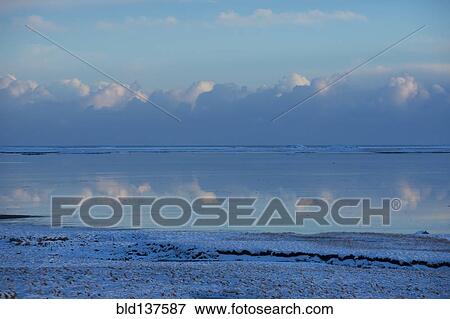 Clouds reflected in still ocean in arctic landscape View Large Photo Image Stock Photo - Clouds reflected in still ocean in arctic landscape. Fotosearch