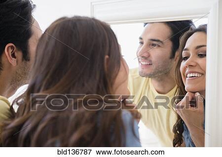 Couple admiring themselves in mirror View Large Photo Image Stock Photo - Couple admiring themselves in mirror. Fotosearch