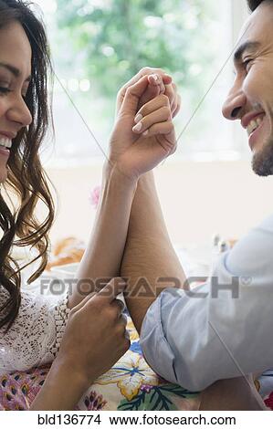 Picture - Couple arm wrestling at table. Fotosearch