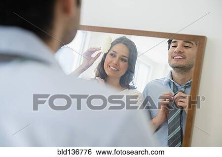 Stock Photograph - Couple dressing in front of mirror. Fotosearch